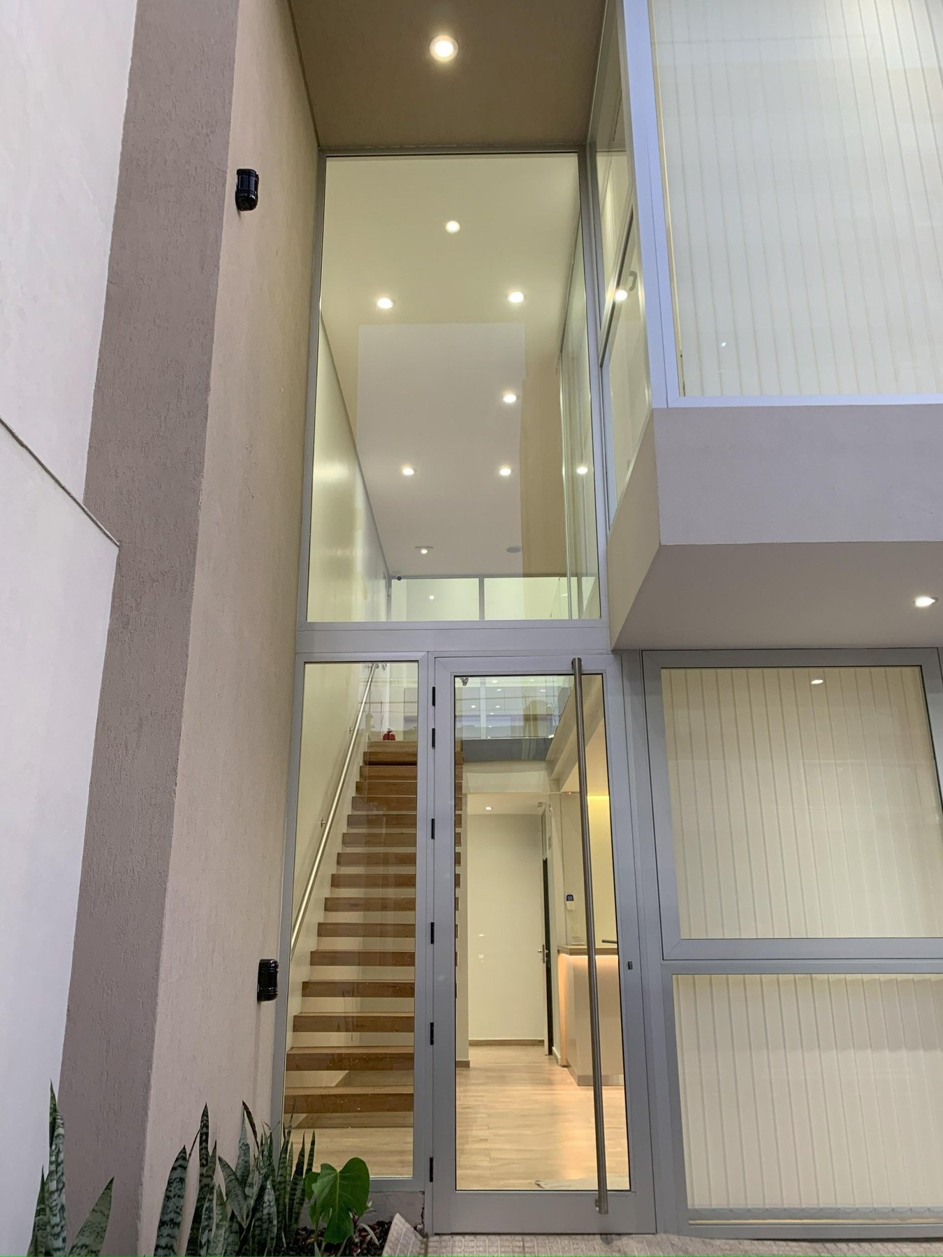 Acceso vidriado hacia escalera interior